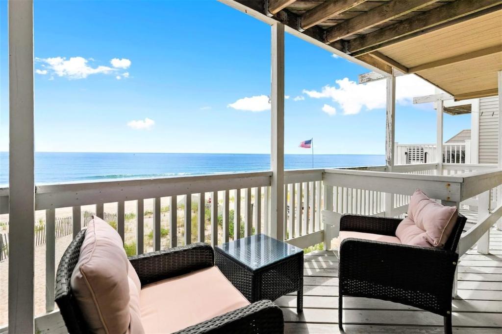 a balcony with two chairs and a table and the ocean at Beachfront Panoramic Views Oceanfront Oasis in Salisbury