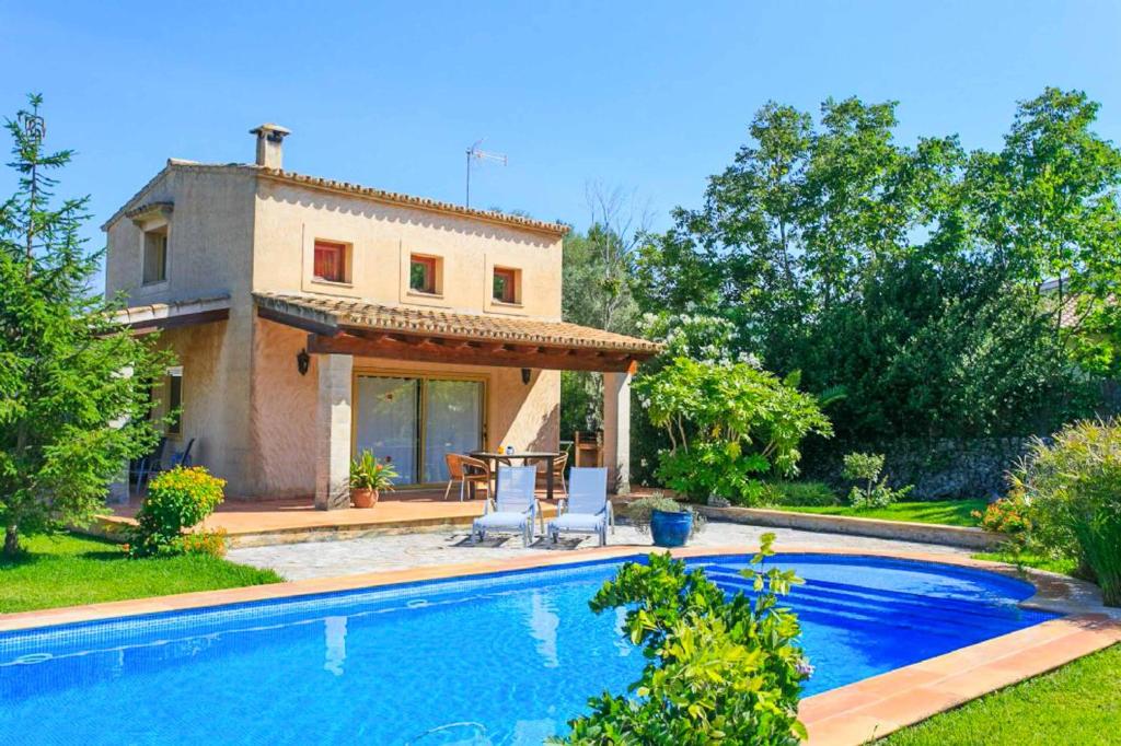 a villa with a swimming pool in front of a house at Casita Luisa in Crestatx