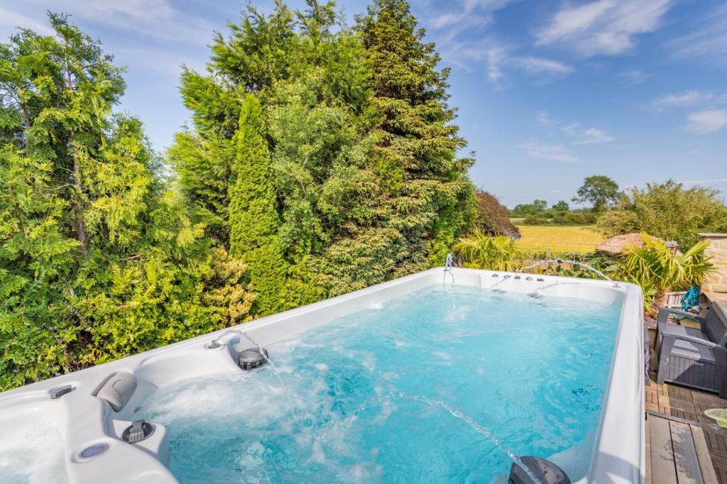 ein Whirlpool in einem Garten mit Bäumen in der Unterkunft Caesars Spa Retreat with Heated Swim Spa & Waterfall Gardens in Darlington