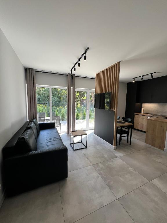 un soggiorno con un divano nero e un tavolo di Property Apart - Work & Stay Suites a Breslavia