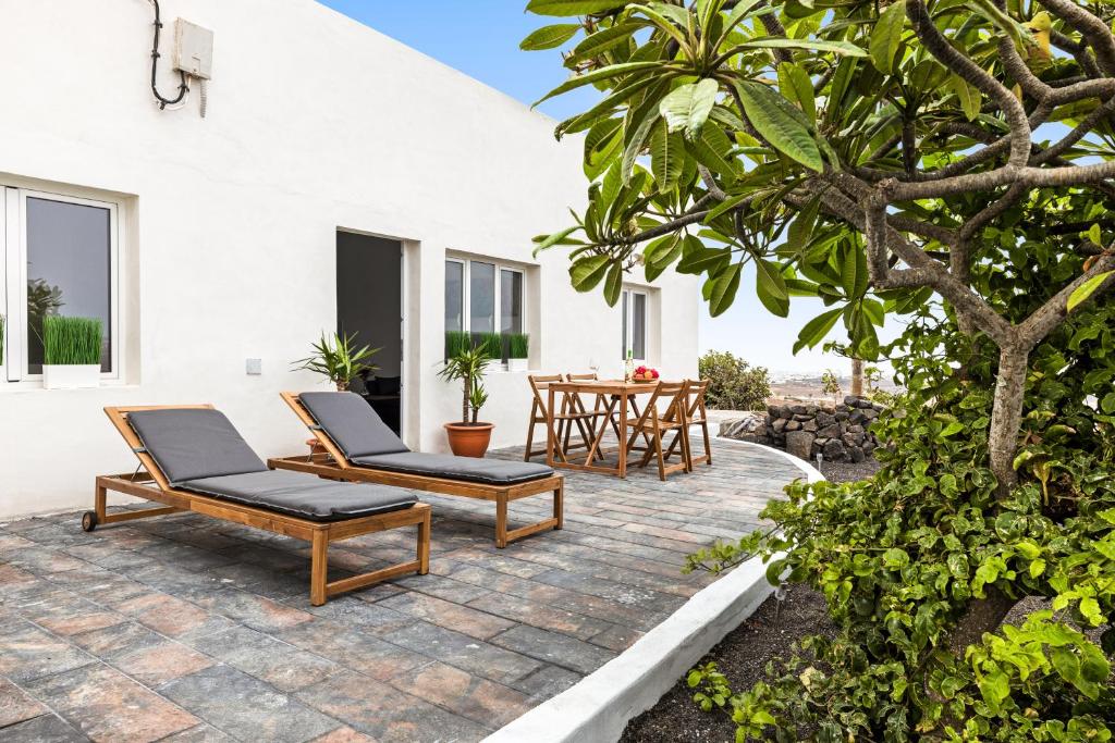 a patio with two chairs and a table at Home2Book Cozy Terrace House with Volcano Views in Nazaret
