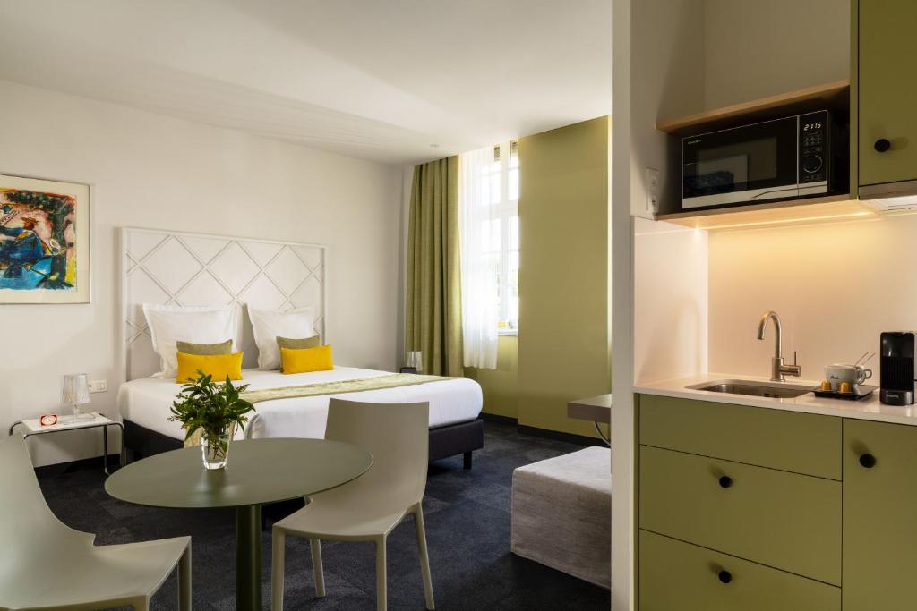 a hotel room with a bed and a table at Villa Diana in Molsheim