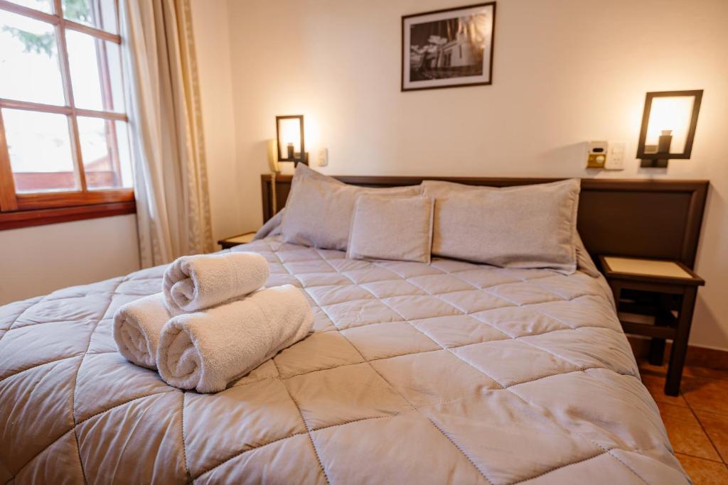 a bedroom with a large bed with towels on it at Apart Hotel Explora Tandil in Tandil