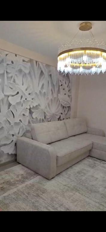 a white couch in a room with a wall at Апартамент in Osh