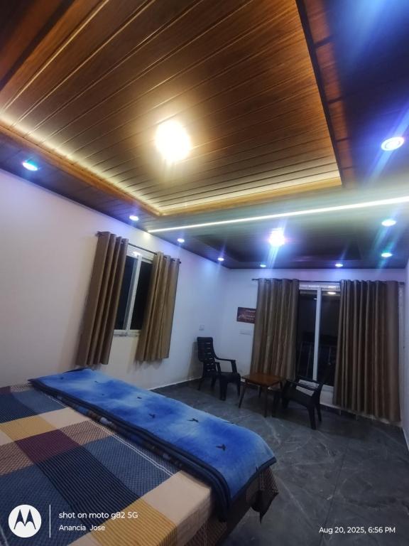ein Zimmer mit einem Bett und einem Tisch und Stühlen in der Unterkunft Star Cottage in Munnar