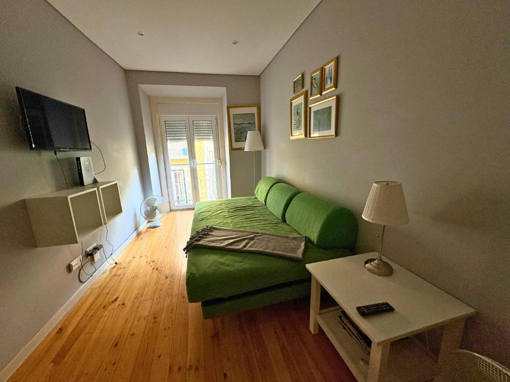 a living room with a green couch and a table at Chiado Hill in Lisbon