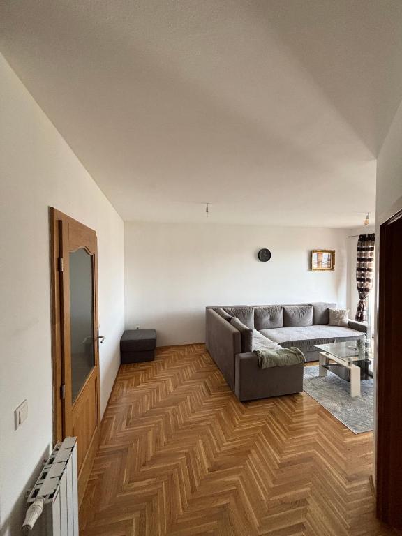 a living room with a couch and a wooden floor at Apartments Tibra in Sarajevo