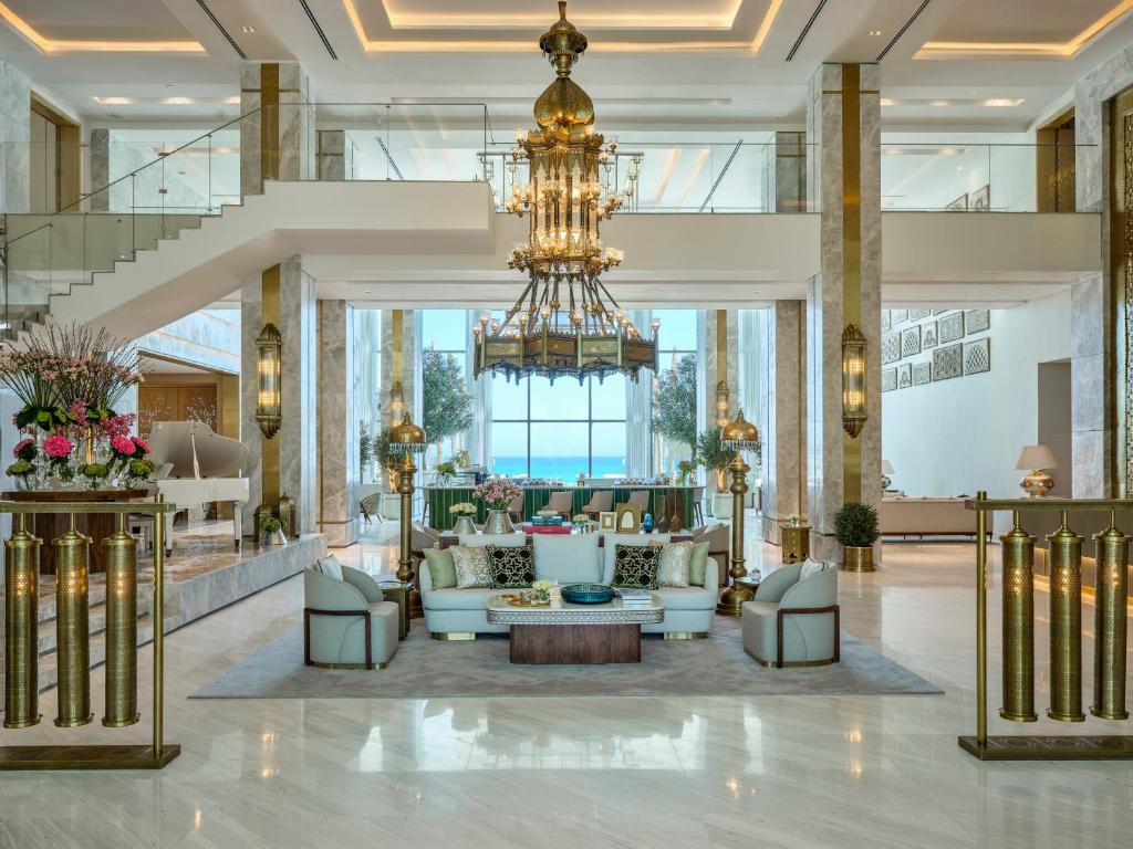 a lobby with a chandelier and couches at Palace Beach Resort in El Alamein