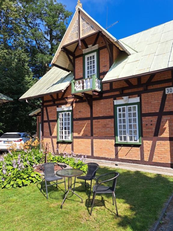 a house with chairs and a table in front of it at Basanavičiaus kambarelis in Palanga