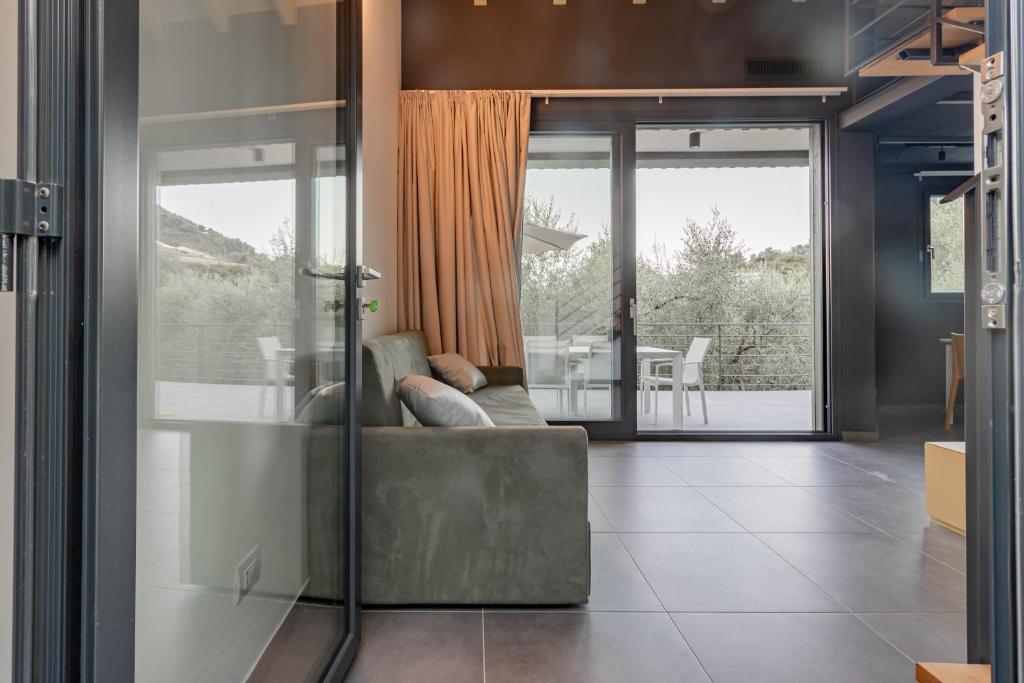 a living room with a couch and a large window at TAGGIASCA- Suite nel verde con piscina e terrazza privata in Arma di Taggia