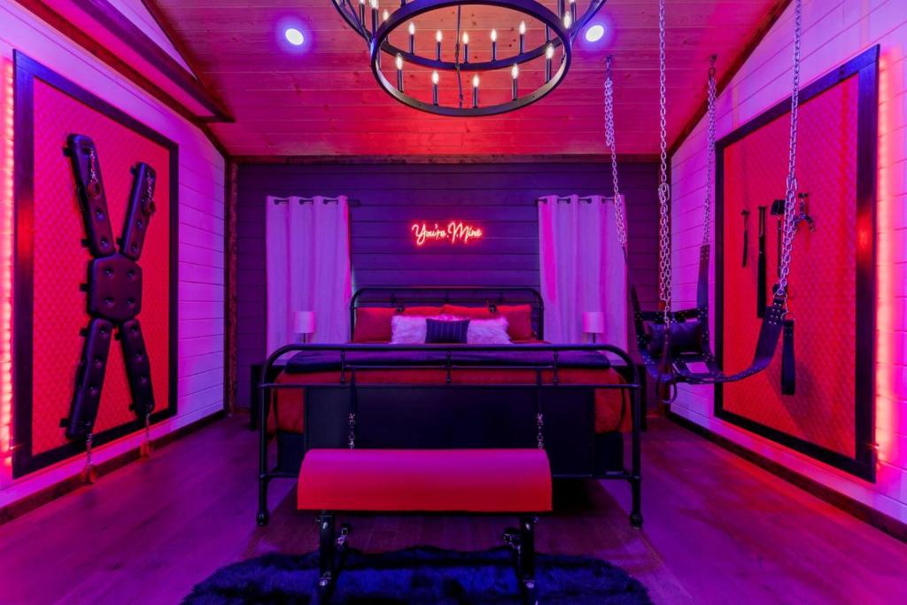 a room with a bed in a pink room at BEARLY BEHAVIN NEW SEXY Cabin Adult Getaway in Broken Bow