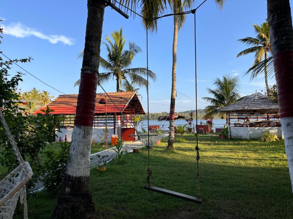 a swing in a yard with palm trees at Lake Homes in Varkala