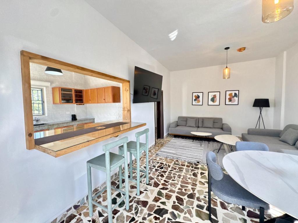 a living room with a counter and a kitchen at Casa Montana 2BR Stone House in Berbara 