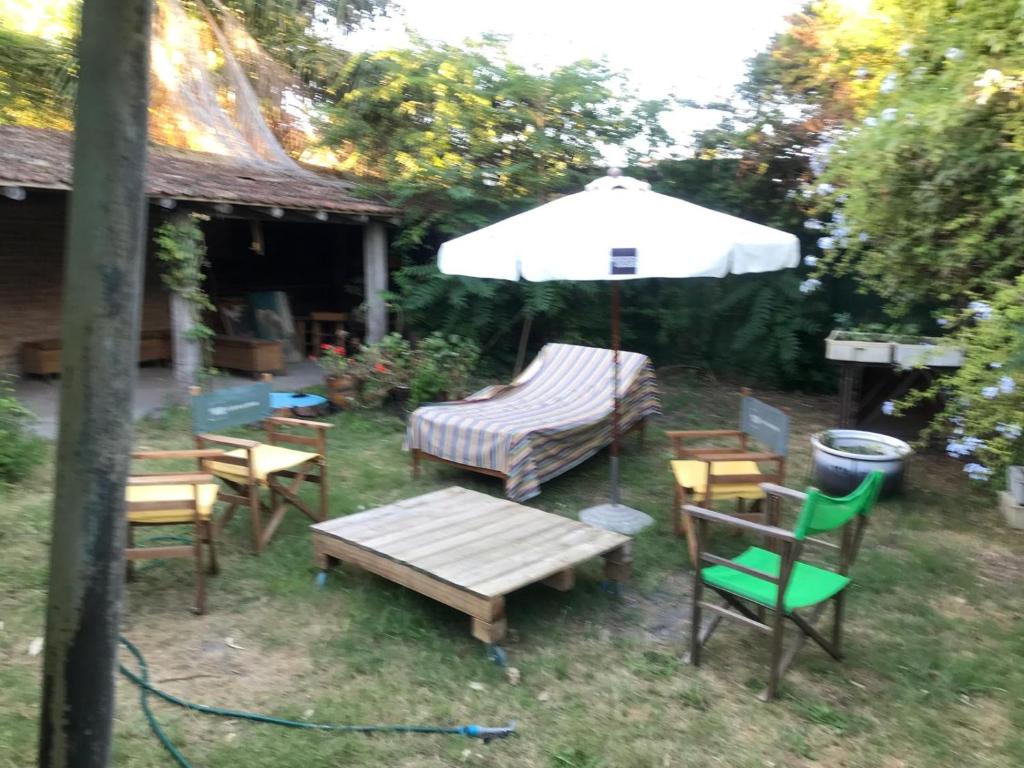 a patio with a table and chairs and an umbrella at Descanso y trabajo con jardín en Barrio Carrasco in Montevideo