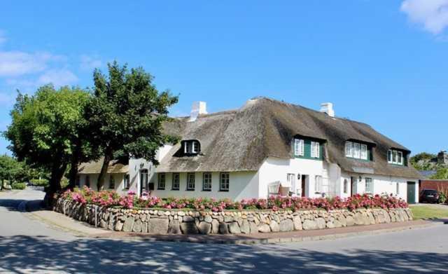een groot wit huis met een rieten dak bij Haus Petje in Keitum