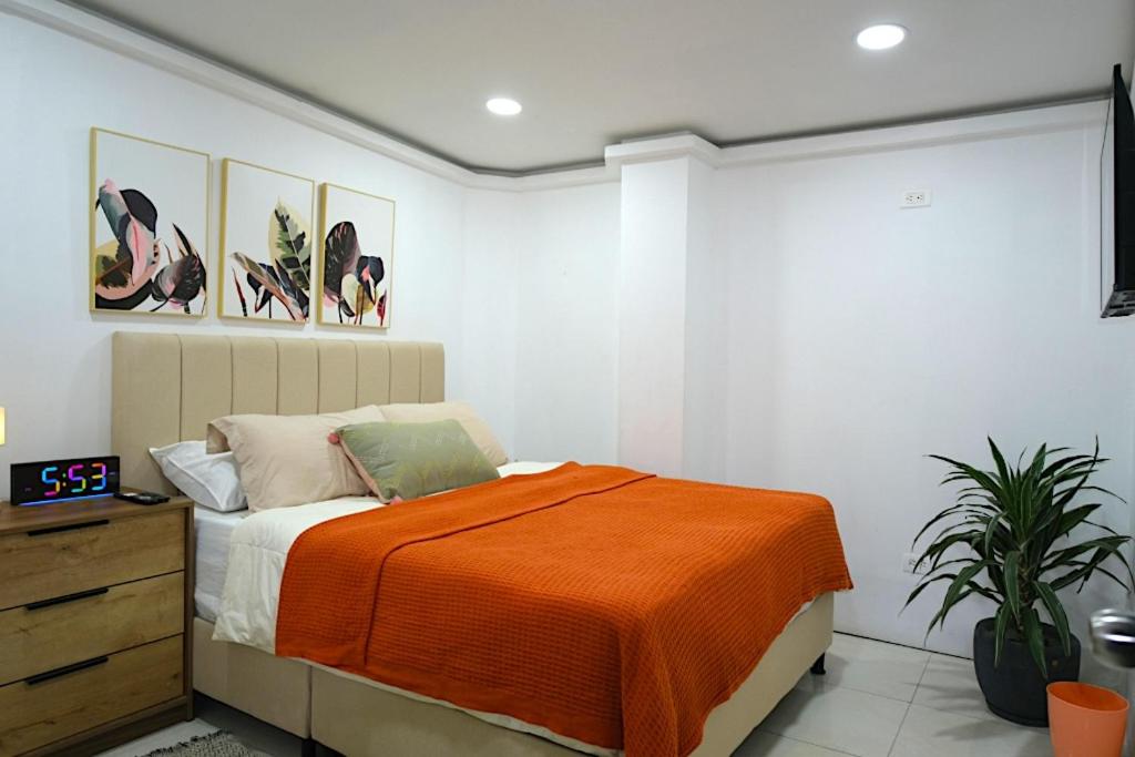 a bedroom with a bed with an orange blanket at Hogar De Ensueño in Envigado