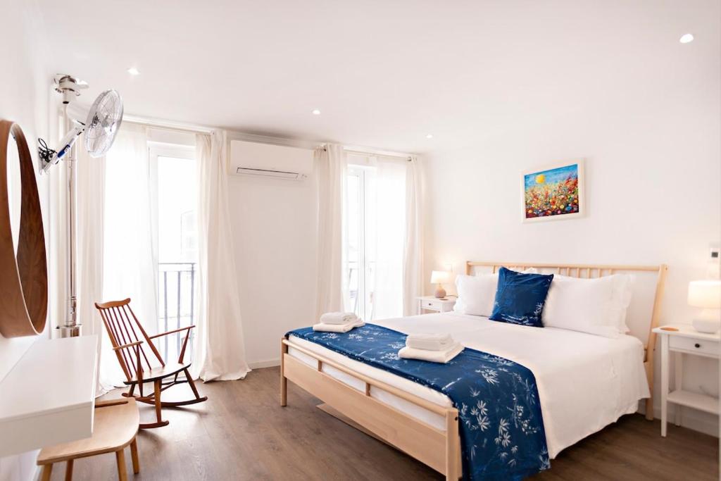 ein weißes Schlafzimmer mit einem großen Bett und einem Schreibtisch in der Unterkunft Casa da Vila in Faro