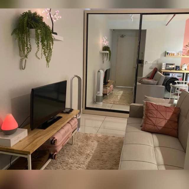 a living room with a couch and a tv at Lovely Luxury Poolview in Kajang