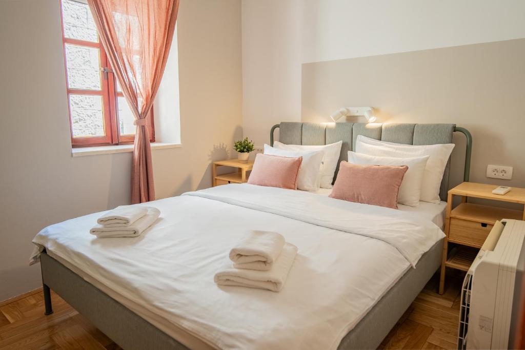 a bedroom with a large bed with towels on it at Old Town Church Bells in Kotor