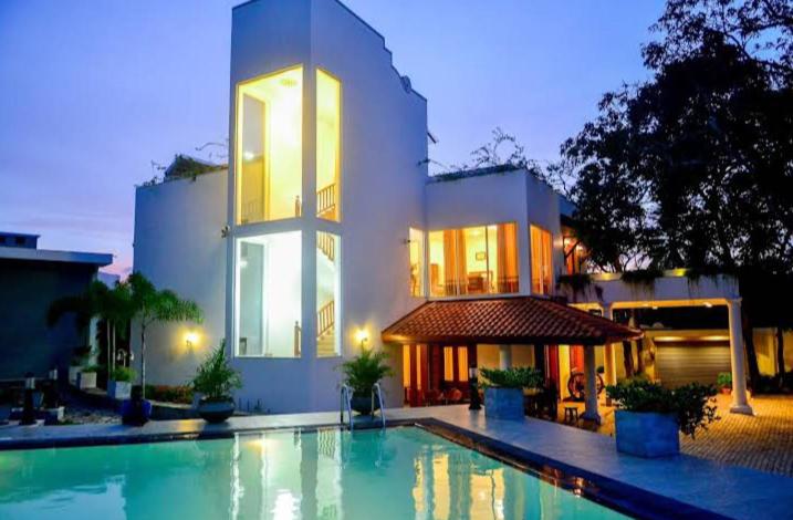 a house with a swimming pool in front of a building at The Elite Villa by Surf & Ride 