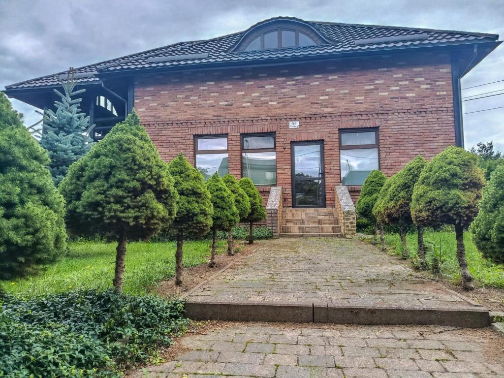 a brick house with a pathway leading to the front door at Willa Mortęgi in Lubawa
