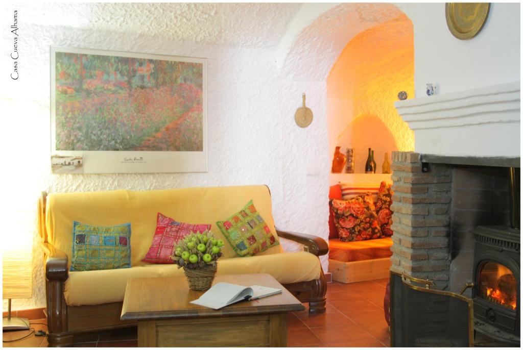 sala de estar con sofá y chimenea en Casa Cueva Alhama en Graena