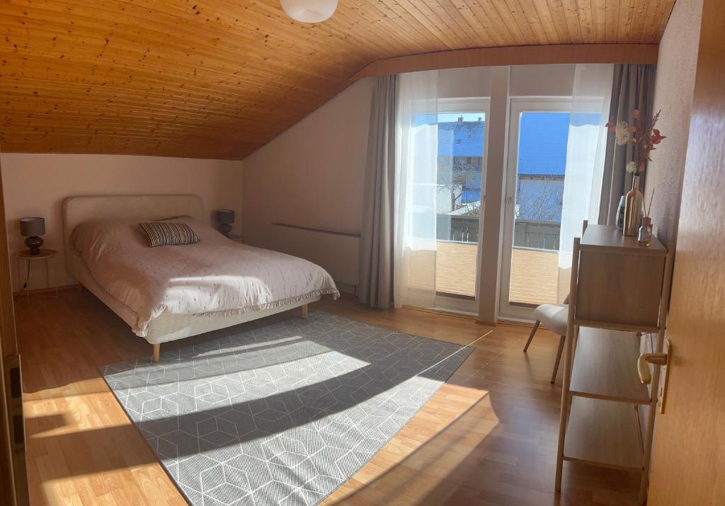 a bedroom with a bed and a large window at Schwarzwald Apartments III in Lenzkirch