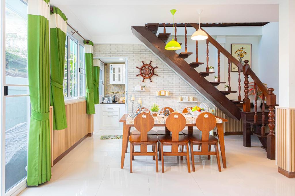 a kitchen with a dining room table with green curtains at Friend House BKK in Bangkok
