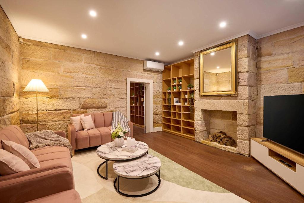 a living room with a stone wall at Parking on Cathedral St House, 5min to Finger Wharf & Royal Botanic in Sydney