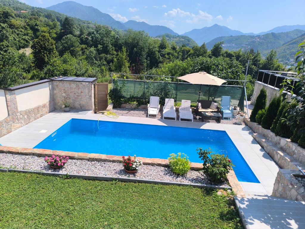 a swimming pool in a yard with mountains in the background at Vila Đul in Konjic