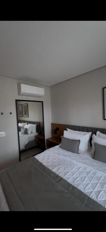 a bedroom with a large bed and a mirror at Apartamento 34 in Pirenópolis
