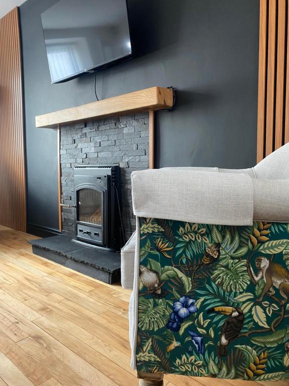 a living room with a couch and a fireplace at Tea Lane Cottage in Carnlough
