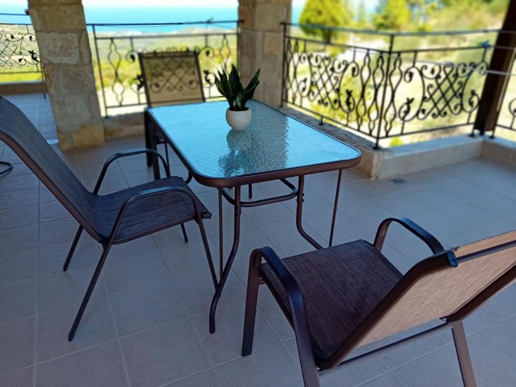a table and two chairs on a balcony at Κτήμα Verde in Agia Paraskevi