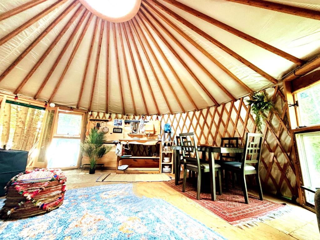 a dining room with a table and chairs in a yurt at Waterfront CedarGrove Yurt-Glamp in Red Bay