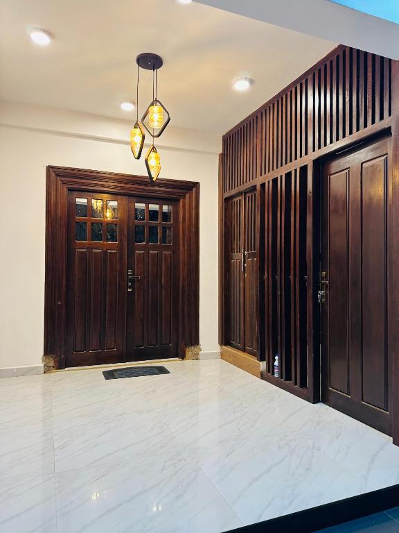 a large room with wooden doors and a chandelier at Nallur Heritage Villa in Jaffna
