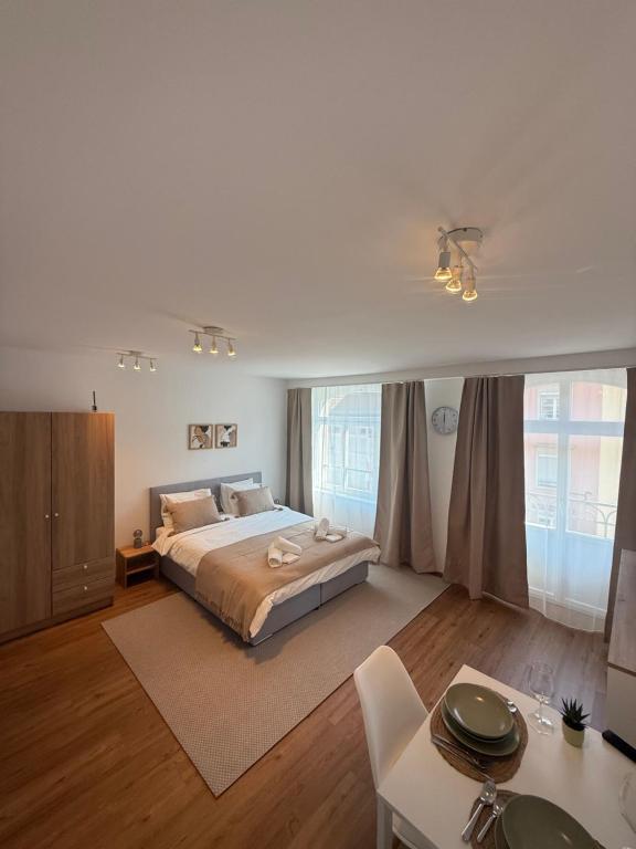 a large bedroom with a large bed and a table at Studio mit Balkon im Zentrum in St. Gallen