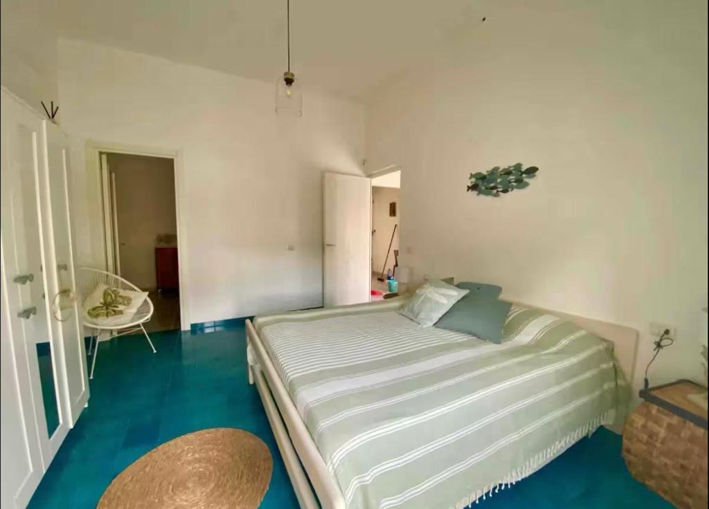 a bedroom with a large bed with blue floors at Casa Carmela in Cozze