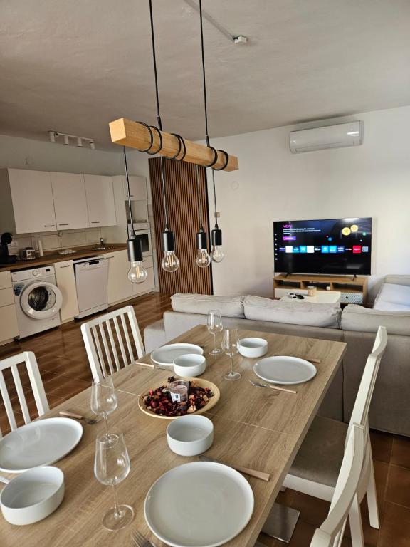a dining room table with white plates and chairs at Dalmara Prezida Apartments in Vir