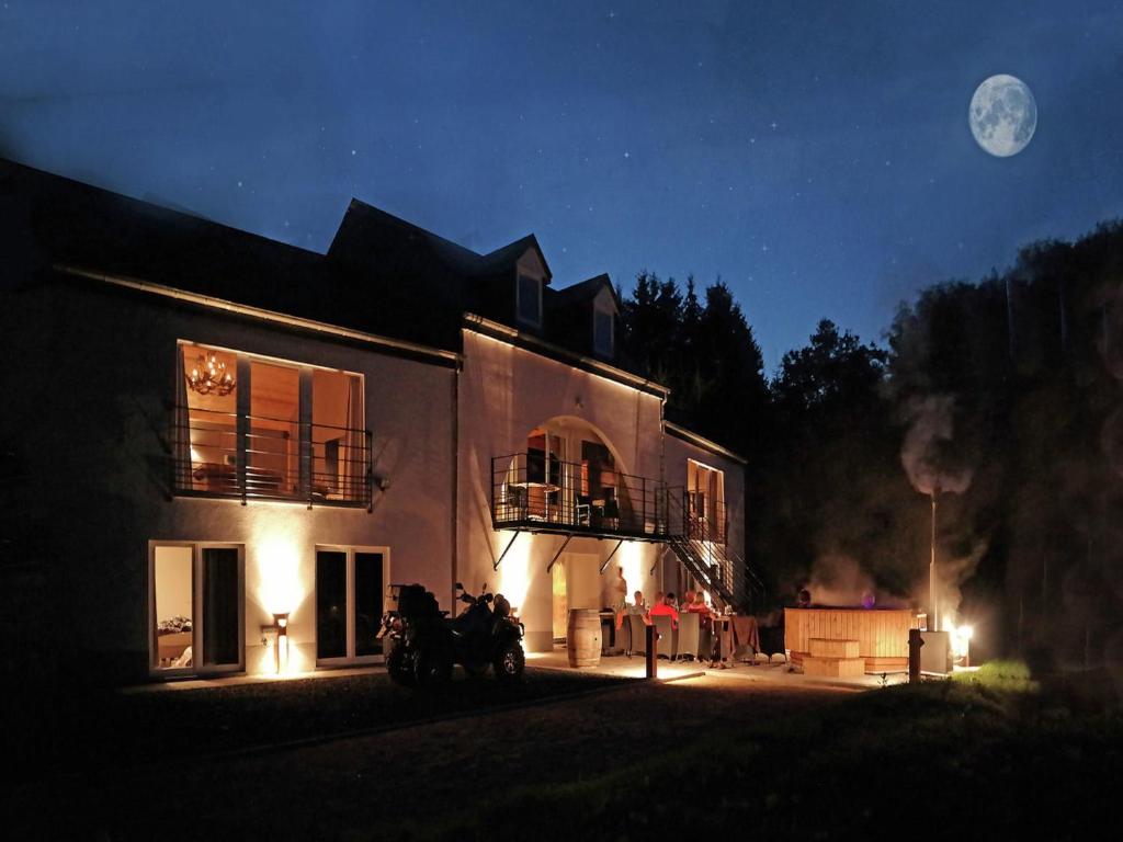 a house with two horses standing outside of it at night at Houffalize Forest View Villa in Wibrin