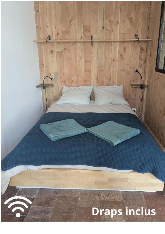 a bed with two pillows on top of it at Studio Eco-Rénové in Saint-Christophe-sur-le-Nais