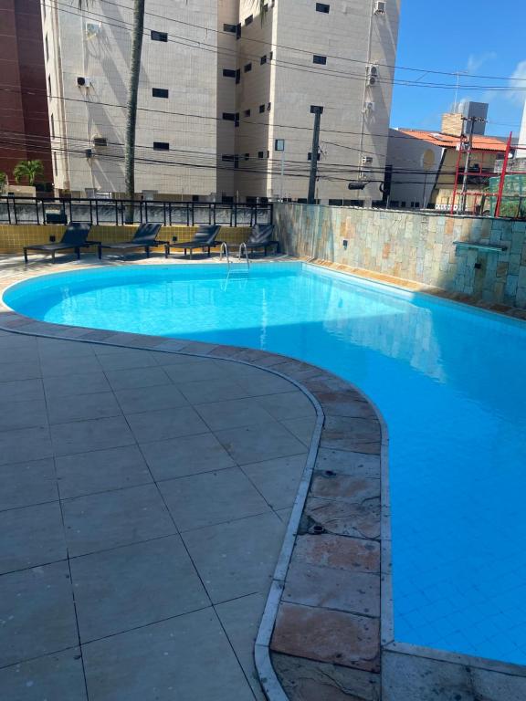 a large blue swimming pool with buildings in the background at Flat Service Praia in Cabedelo