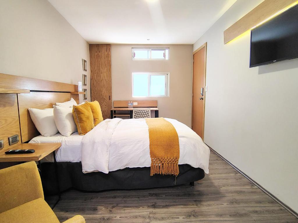 a hotel room with a bed and a television at Casa Pánuco in Mexico City