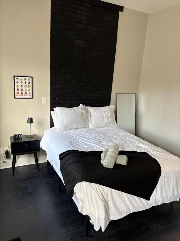 een slaapkamer met een groot bed met een zwart hoofdeinde bij Luxe in the Lou in Saint Louis