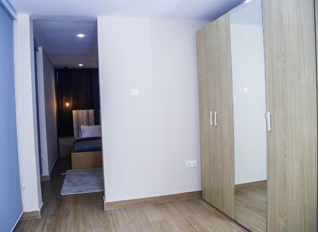 a room with a door and a bedroom with a bed at PLSA 1bedrooms at airport city in Accra