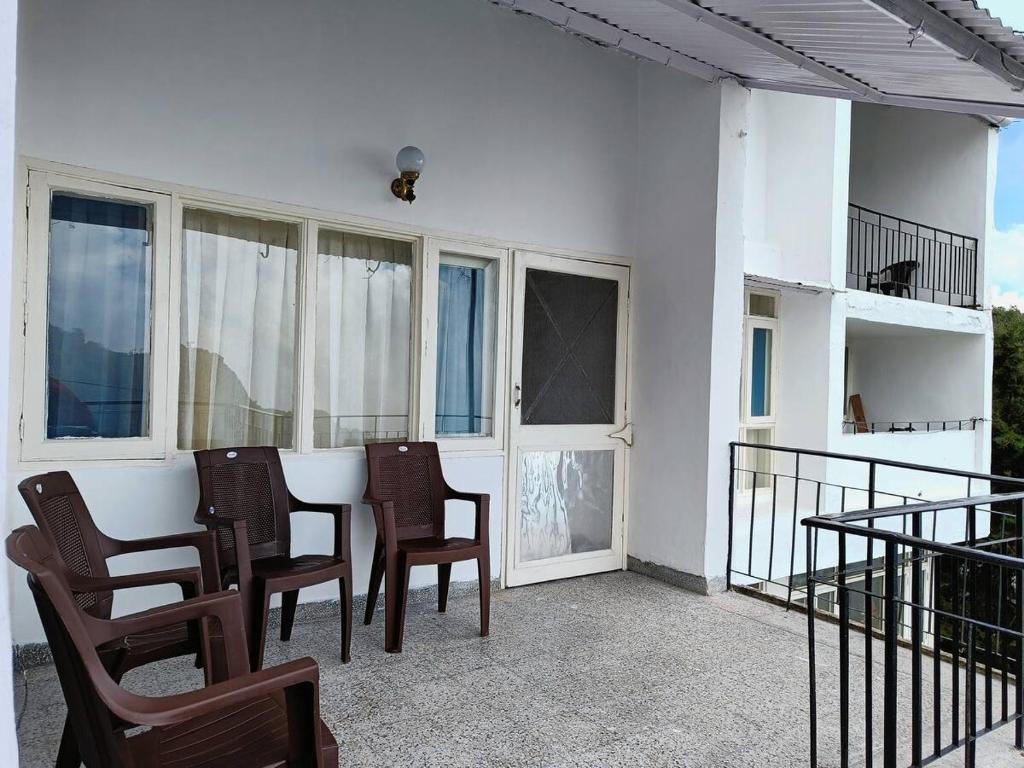 un tavolo e delle sedie sul balcone di una casa di After Dun Delight a Mussoorie