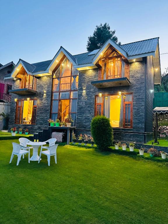 a house with a table and chairs in the yard at Cliffside cottage in Tangmarg