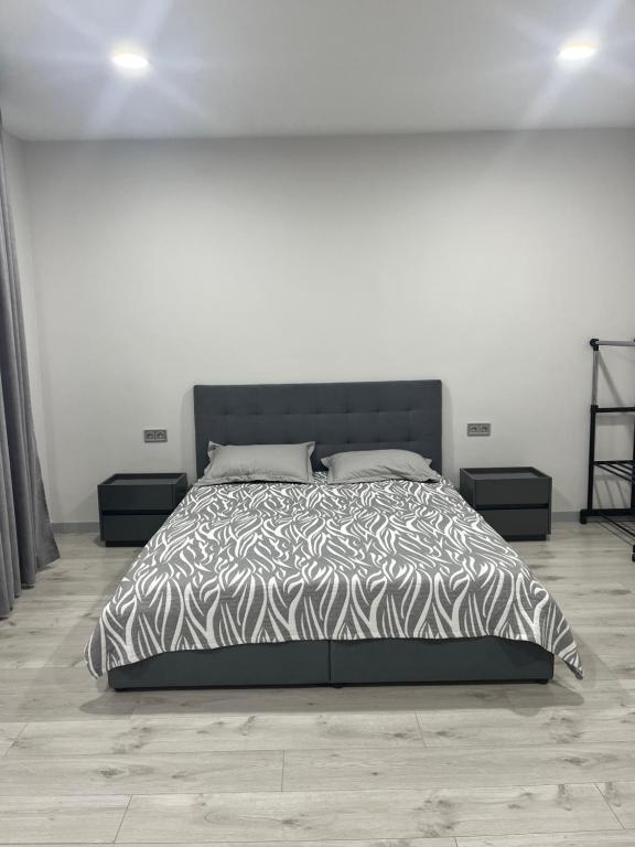 une chambre avec un lit avec une couette noire et blanche dans l'établissement 1-комнатная квартира, à Tchornomorsk