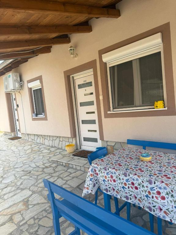 a house with a table and two blue chairs at Dolina Ruža in Bogutovac