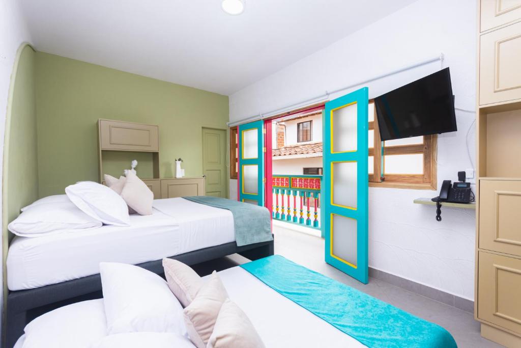 Habitación con 2 camas y TV. en Hotel Chromatic, en Guatapé