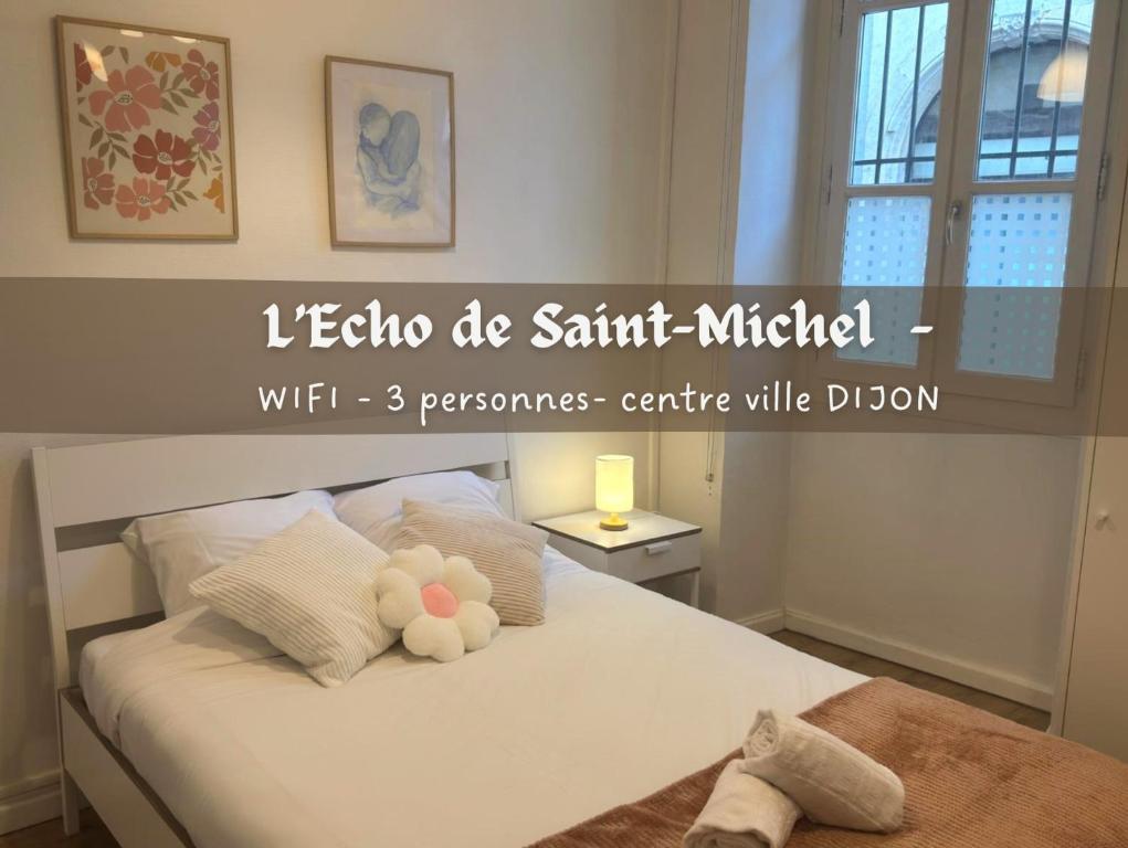 a bedroom with a white bed with a stuffed animal on it at L'écho de Saint-Michel - Dijon in Dijon